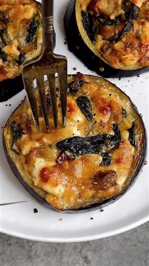 SPINACH & CHEESE STUFFED EGGPLANT ROUNDS! Another of my most viral recipes from 2025. These babies are incredible—super simple & so👏damn👏tasty👏 I used a cookie cutter to make cut the holes, but you can easily use a knife. These would make an epic NYE app • 1 large eggplant 1 large yellow onion, chopped 3 tbsp olive oil, plus more for brushing tops 1/2 tsp salt Pepper to taste 4 oz baby spinach 1 cup crumbled feta cheese 1 cup shredded mozzarella 1/2 cup shredded Parmesan cheese 1 egg • 1️⃣Pre