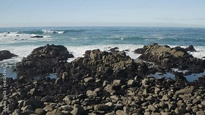 4K cinematic smooth dolly shot over California's rocky coast and the churning Monterey Bay.