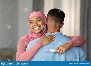 Joyful Black Islamic Lady Embracing Husband And Holding Positive