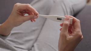 Woman Measuring Normal Body Temperature Using An Electronic Thermometer