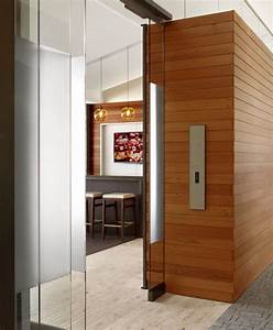 An Open Door Leading To A Kitchen And Dining Room With Wood Paneling On
