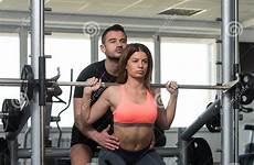 personal trainer woman squat helping squats barbell exercise gym stock