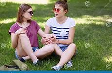 fun legs women look sunglasses sit wears crossed lesbians grass together each green other while preview