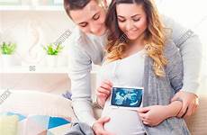 couple pregnant baby expecting mom dad happy young ultrasound holding waiting her
