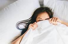 under blanket hiding bed woman