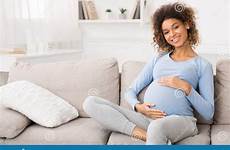 pregnant sofa sitting woman happy caressing belly her