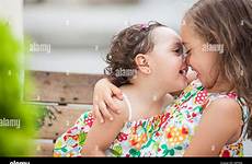 sisters two kissing stock girls alamy between cute beautiful