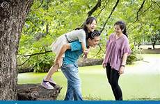 family enjoying piggyback laugh giving smiling active father ride daughter having mother together asian happy fun beautiful outdoor