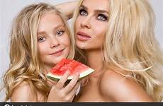 mother pirang pelukan semangka mereka memegang putri bergembira stok