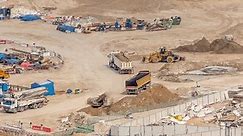 Foundation pit for construction of apartment complex building aerial timelapse. Deep installation and excavation with heavy machinery as excavators, bulldozers and trucks, Dubai