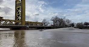 Boat drives under Tower Bridge as Sacramento River rises from rain
