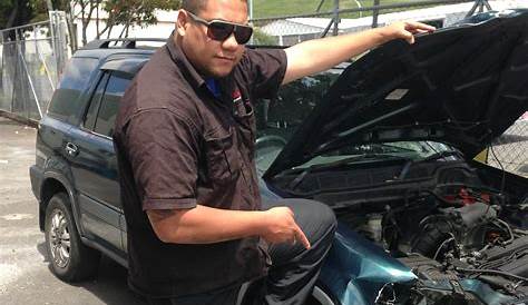 a man standing next to a wrecked car