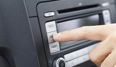 a person pressing the buttons on a car radio