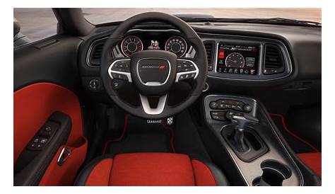 the interior of a sports car with red and black leather trims, steering wheel, dash lights, and