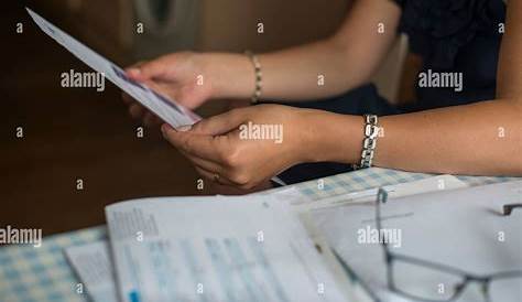 Woman reading credit card statement Stock Photo - Alamy