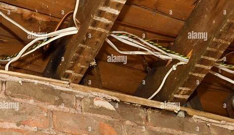 Old electrical wiring and copper pipe under the floorboards of a 1930