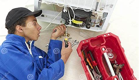 Repairman Doing Maintenance Over a Refrigerator Stock Image - Image of