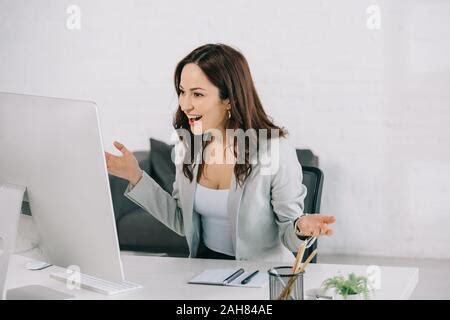 excited, surprised secretary looking at computer monitor while sitting ...