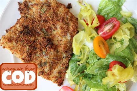 A White Plate Topped With Meat And Salad Next To A Fried Chicken Cut In