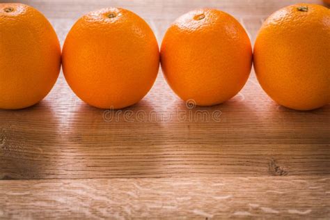 Four Orange Fruits Organized In Row On Wooden Stock Photo Image Of