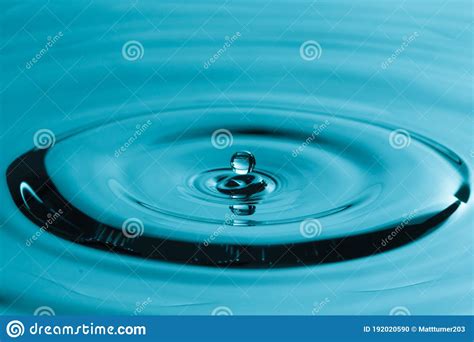 Perfect Water Drop Splashing Into Smooth Water Causing Ripples Stock
