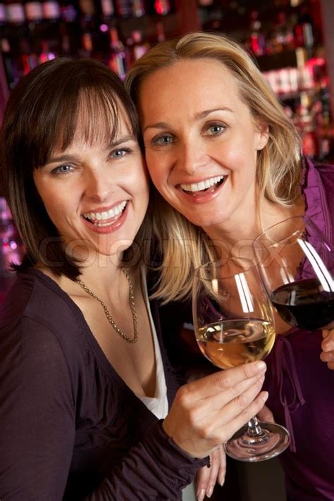 Two Women Enjoying Drink Together In Bar Stock Photo Colourbox