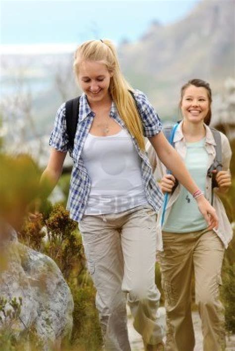 Two Young Woman Go Hiking Outdoors And Smile As They Walk Go Hiking