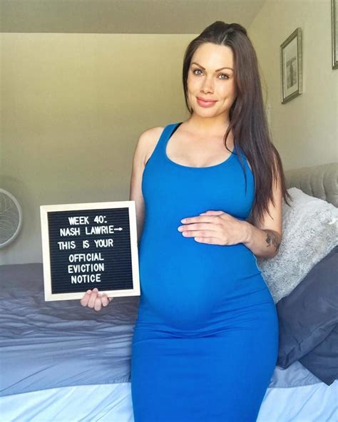 A Pregnant Woman In A Blue Dress Holding A Sign