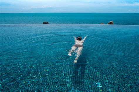Premium Photo Woman Relaxing In Infinity Swimming Pool Water