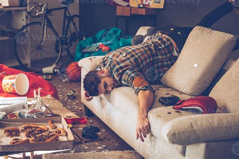 When The Party Is Over Young Handsome Man Passed Out On Sofa In Messy Room After Party 13577700