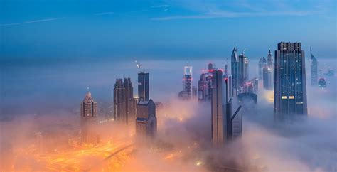 Online Crop High Rise Buildings Covered By Fog Under Blue Sky Hd