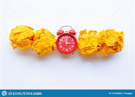 anillo rojo del despertador con la bola de papel arrugada amarilla aislada en blanco foto de