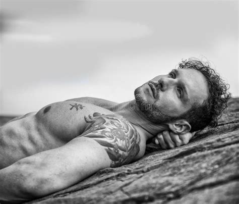 Handsome Muscular Man On The Beach Laying On Rocks Stock Photo Image
