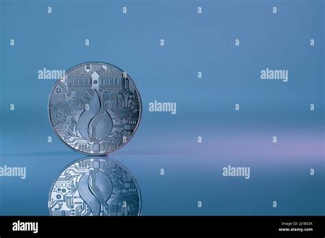 Huobi Ht Cryptocurrency Physical Coin Placed On The Reflective Surface And Lit With Blue And