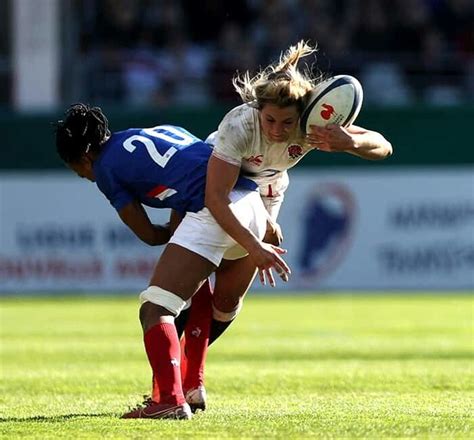 Two Women Are Playing Rugby On The Field