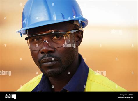 Portrait Of A Young Zambian Man In Blue Hard Hat And Safety Goggles