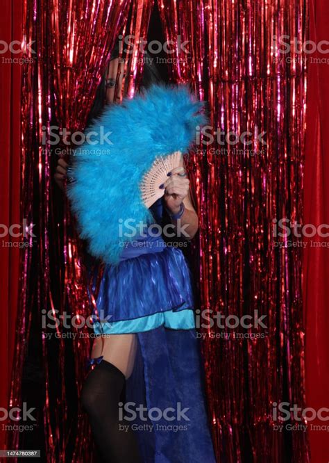 Woman Wearing Blue Corset Preforming Burlesque Dance With Feather Fan