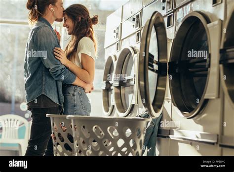 Couple Standing In A Laundry Room Holding Each Other Listening To Music
