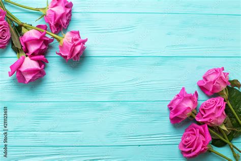 Border From Pink Roses Flowers On Teal Color Wooden Background Floral