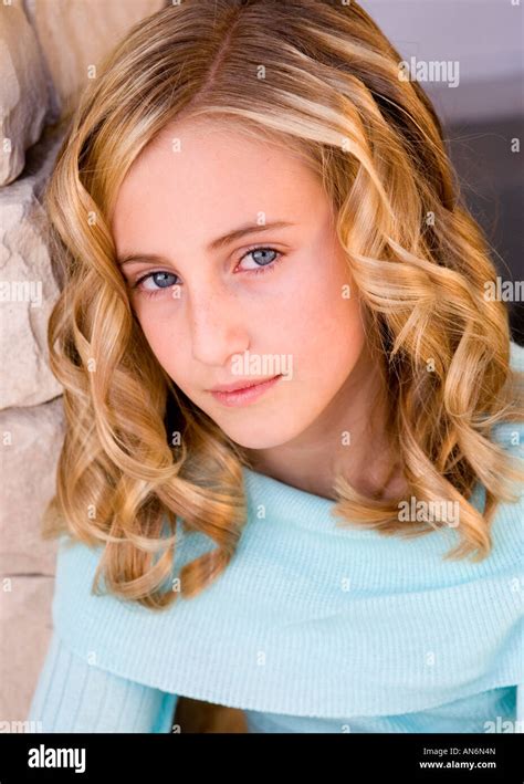 Young Girl With Blond Curly Hair Blue Eyes And Blue Shirt Leaning
