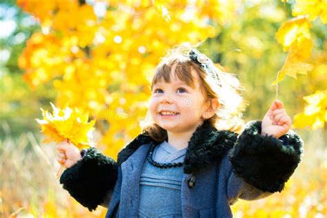 Happy Little Child Baby Girl Laughing And Playing In The Autumn On The