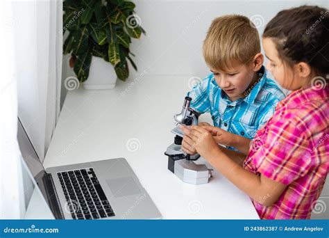 Two Teenagers Helping Each Other With A Microscope Stock Image Image