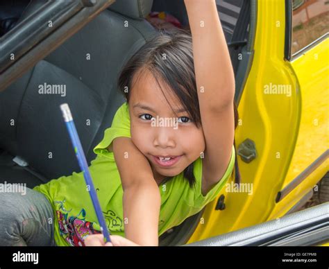 Asian Kids Girl Playing In Yellow Car And Show The Pencil Stock Photo