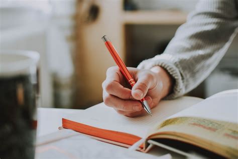 Find the best free stock images about person writing. person holding on red pen while writing on book photo ...