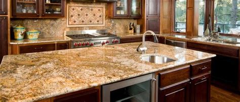 The warm tones of the cabinetry allow the dark greens of the counter to stand out more, as does the cream color of the walls. Granite | Sander & Sons