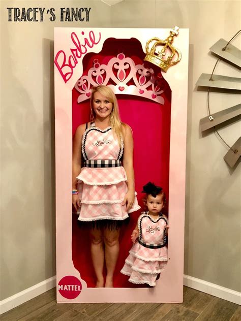 A Woman And Her Daughter Are Standing In A Barbie Doll Box With The