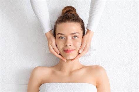 Pretty Young Woman Relaxing During Face Lifting Massage Top View Stock