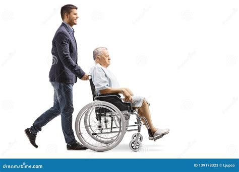 Young Man Pushing An Elderly Male Patient In A Wheelchair Stock Image
