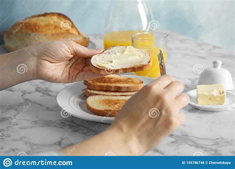 Woman Spreading Butter Onto Slice Of Bread Over Marble Table Stock Photo Image Of Dinner Cook