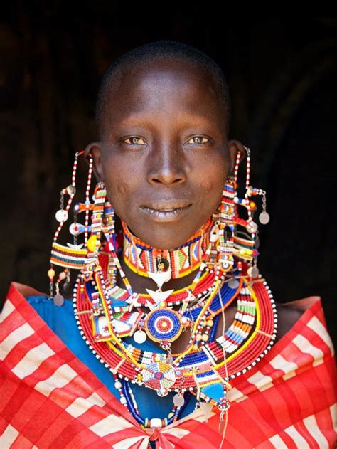 Intricate Beading Flows Around A Maasai Tribeswoman Dressed In Traditional Clothing Near